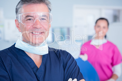 Smiling dentist with protective glasses