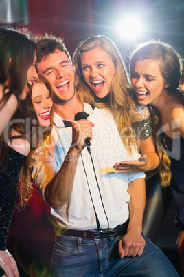 Happy friends singing karaoke together