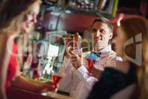 Handsome barman chatting to customers