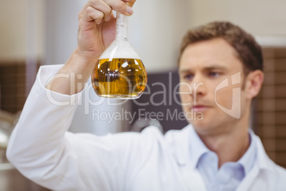 Focused scientist holding beaker with beer