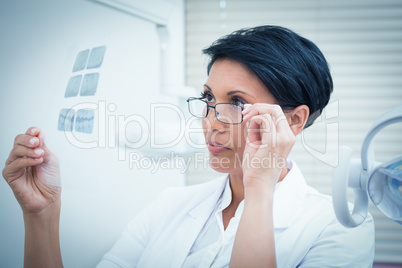 Female dentist looking at x-ray