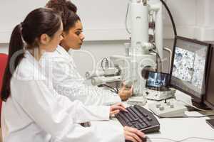 Science students looking at microscopic image on computer