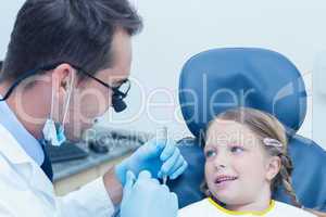 Male dentist examining girls teeth