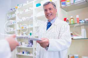 Pharmacist handing a prescription to somebody