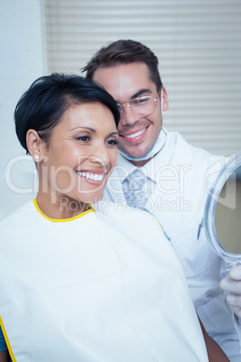 Smiling young woman looking at mirror