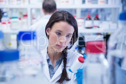 Young chemist picking up the bottles on the shelf