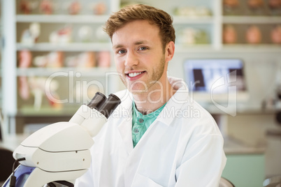 Young scientist working with microscope