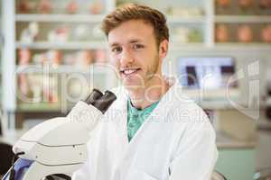 Young scientist working with microscope