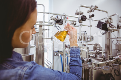 Stylish girl in denim jacket holding beaker of beer