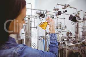 Stylish girl in denim jacket holding beaker of beer