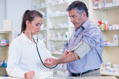 Trainee listening to patients pulse with stethoscope