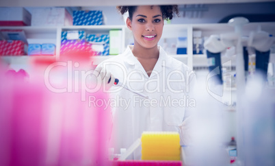 Pretty science student using pipette