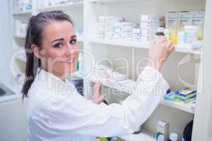 Smiling student taking jar from shelf