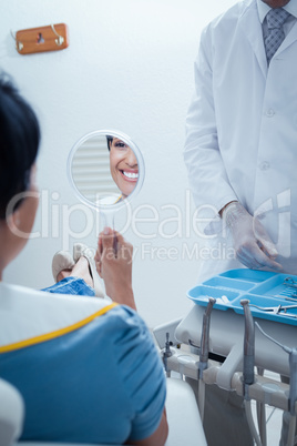 Smiling young woman looking at mirror