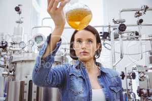 Stylish girl in denim jacket holding beaker of beer