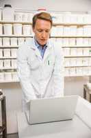 Focused pharmacist using his laptop