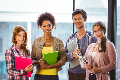 Four smiling classmates standing in front of the window