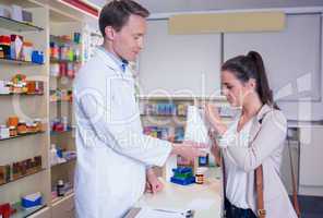 Pharmacist giving a bag of drugs to his sick client