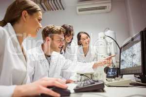 Science students looking at microscopic image on computer