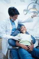 Female dentist examining boys teeth