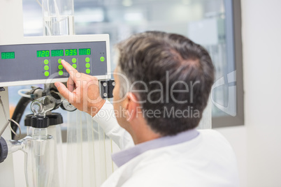 Pharmacist using machinery to make medicine