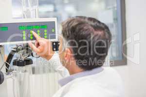 Pharmacist using machinery to make medicine