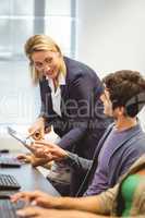 Teacher helping boy with tablet pc