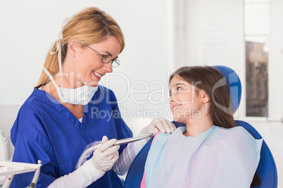 Smiling pediatric dentist reassuring her young patient