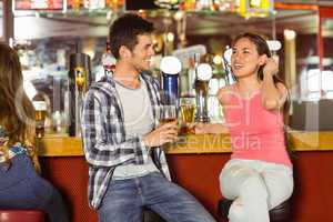 Smiling friends drinking beer together