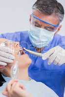 Dentist wearing surgical mask and safety glasses