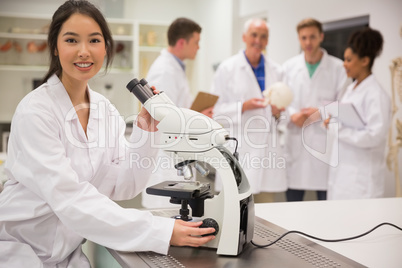 Young medical student working with microscope