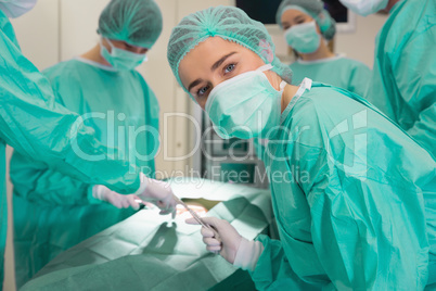 Medical student looking at camera during practice surgery