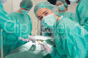 Medical student looking at camera during practice surgery