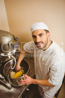 Baker using large mixer to mix dough