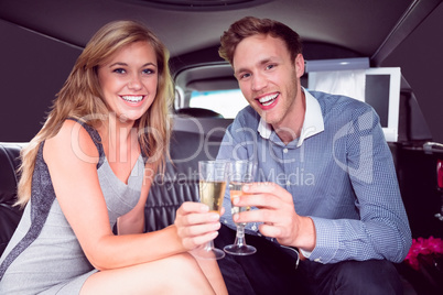 Happy couple drinking champagne in limousine