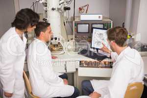 Biochemistry students using large microscope and computer