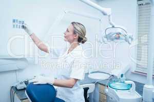 Concentrated female dentist looking at x-ray