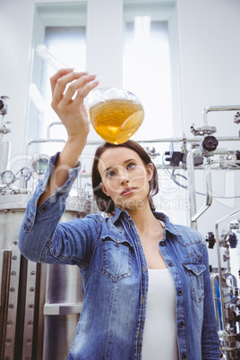 Stylish girl in denim jacket holding beaker of beer