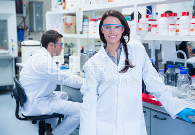 Portrait of a smiling chemist leaning against desk