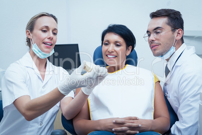 Dentists showing woman prosthesis teeth