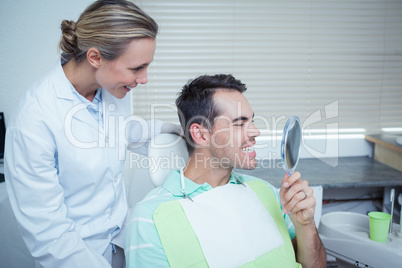 Smiling young man looking at mirror