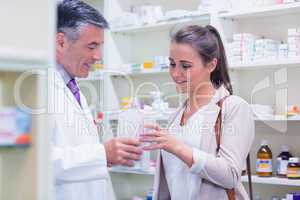 Pharmacist giving paper bag to his customer