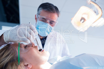 Dentist examining a patients teeth under bright light