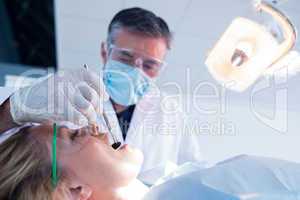 Dentist examining a patients teeth under bright light