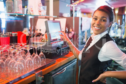 Pretty barmaid using touchscreen till