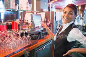 Pretty barmaid using touchscreen till