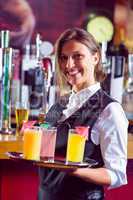 Barmaid holding tray of cocktails