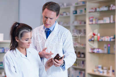 Pharmacist showing medication to his trainee