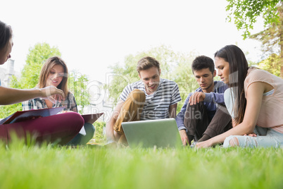 Happy students sitting outside on campus