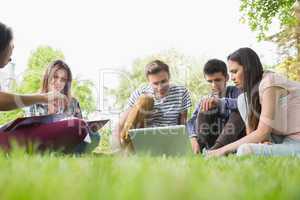 Happy students sitting outside on campus